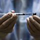 A medical technician holding a dose of the Johnson & Johnson covid-19 vaccine.